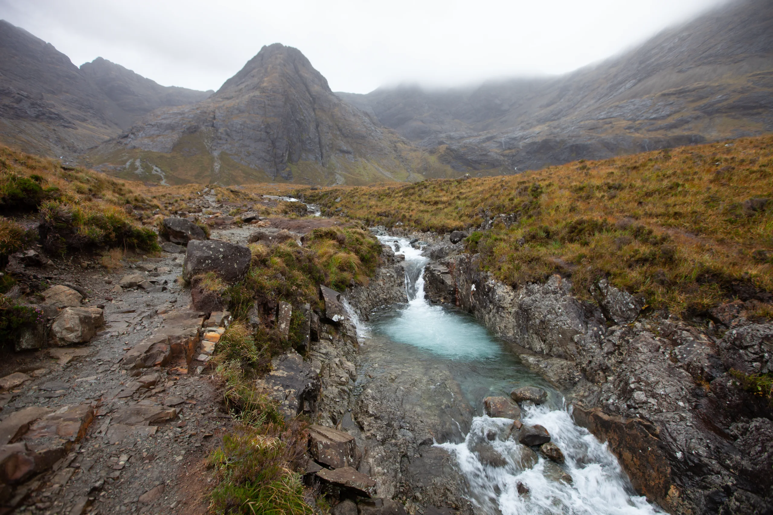 Clear aqua stream flowing beneath the Cuillin mountains at the Fairy Pools on the Isle of Skye