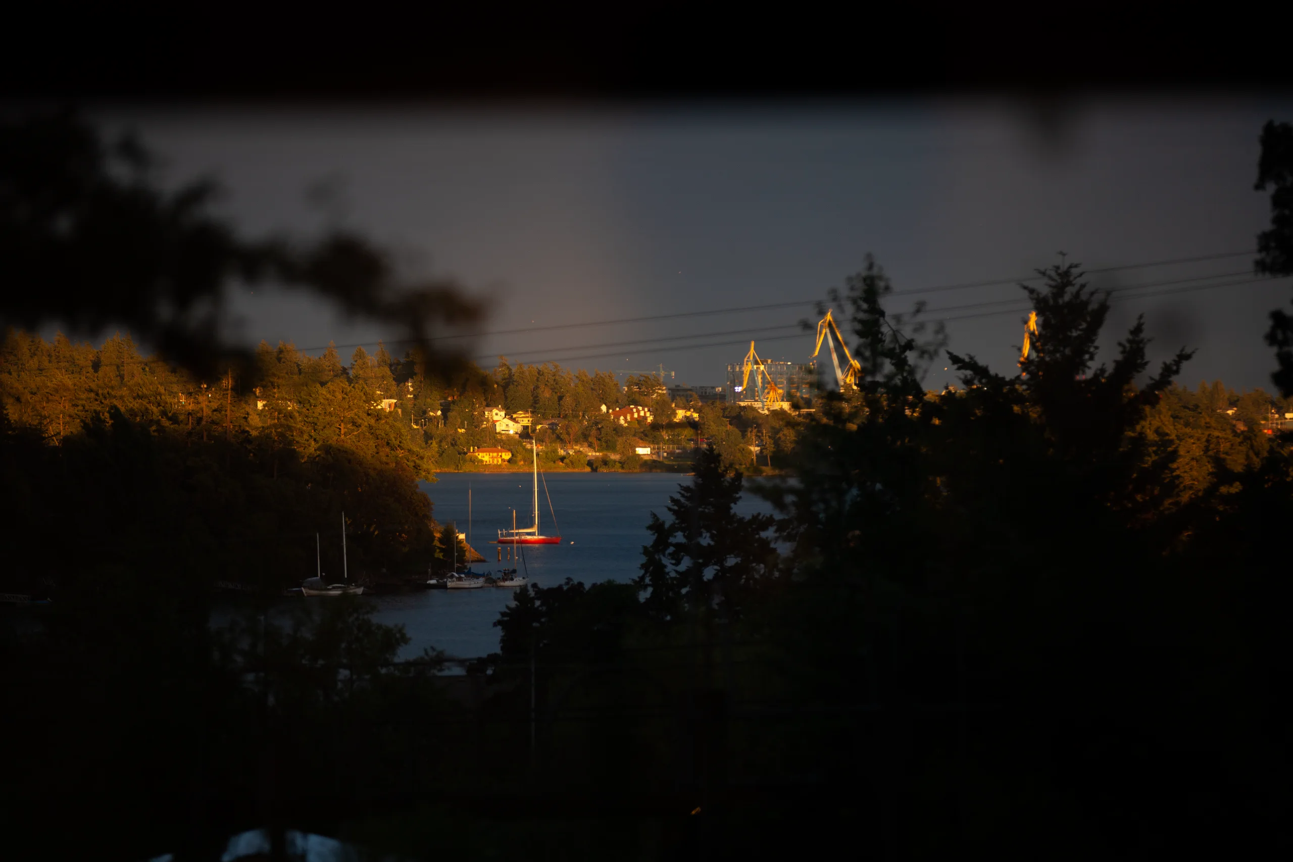 Night view from Atkins across Esquimalt Harbour toward illuminated shoreline and industrial lights