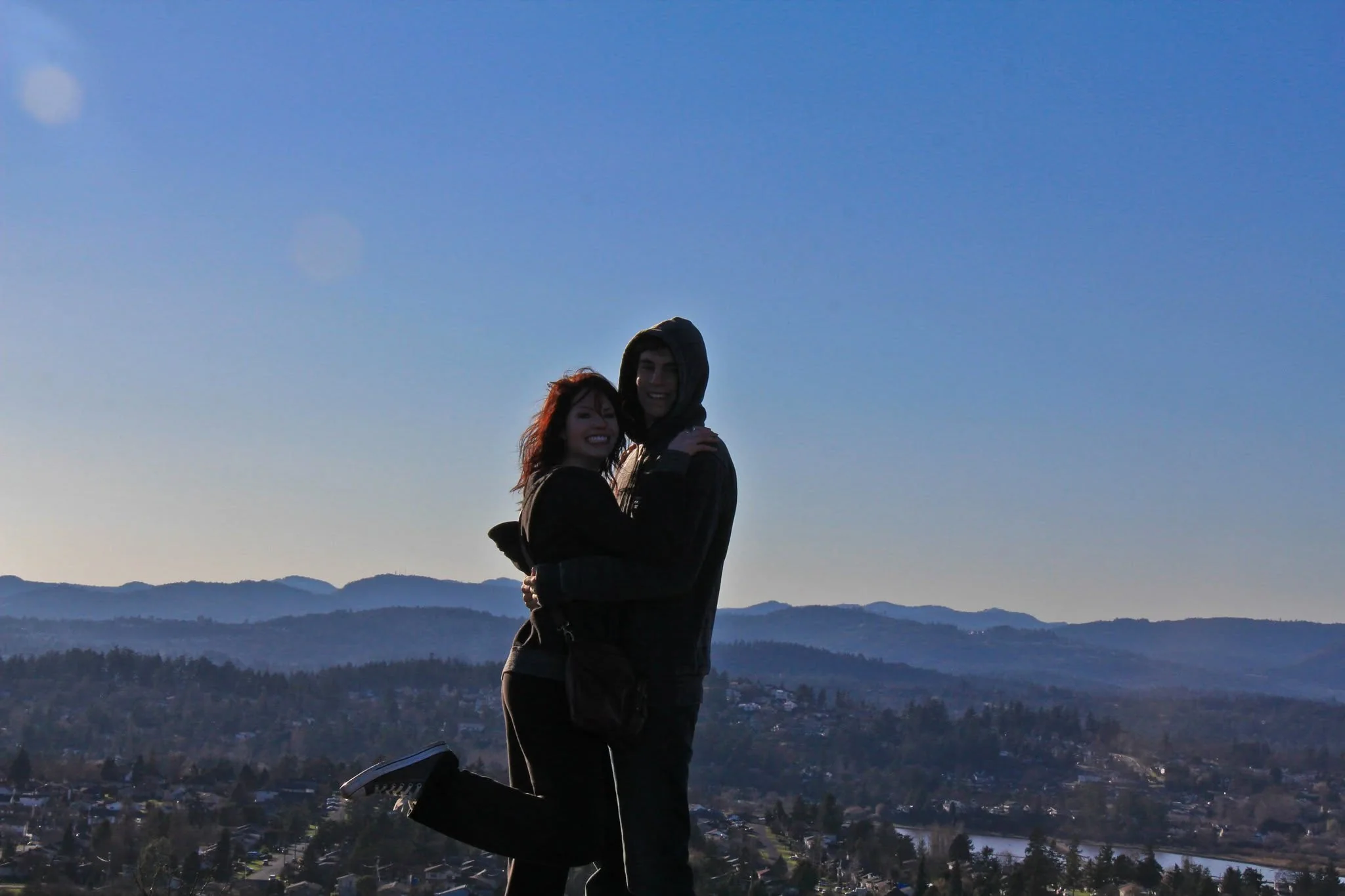 Megan and Owen embracing on a hilltop after his return from Australia