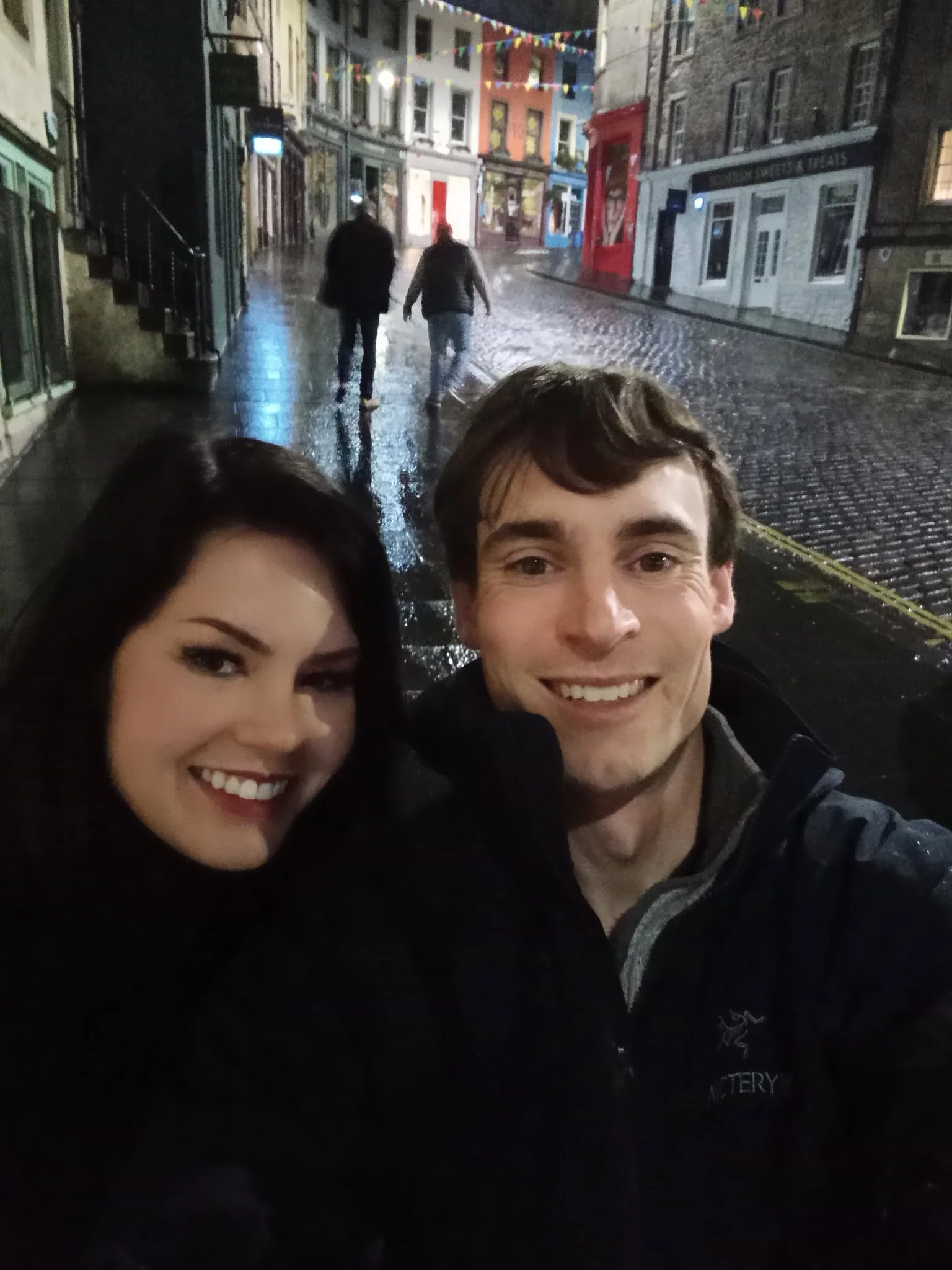 Owen and Megan smiling together on a rainy evening during their honeymoon in Scotland
