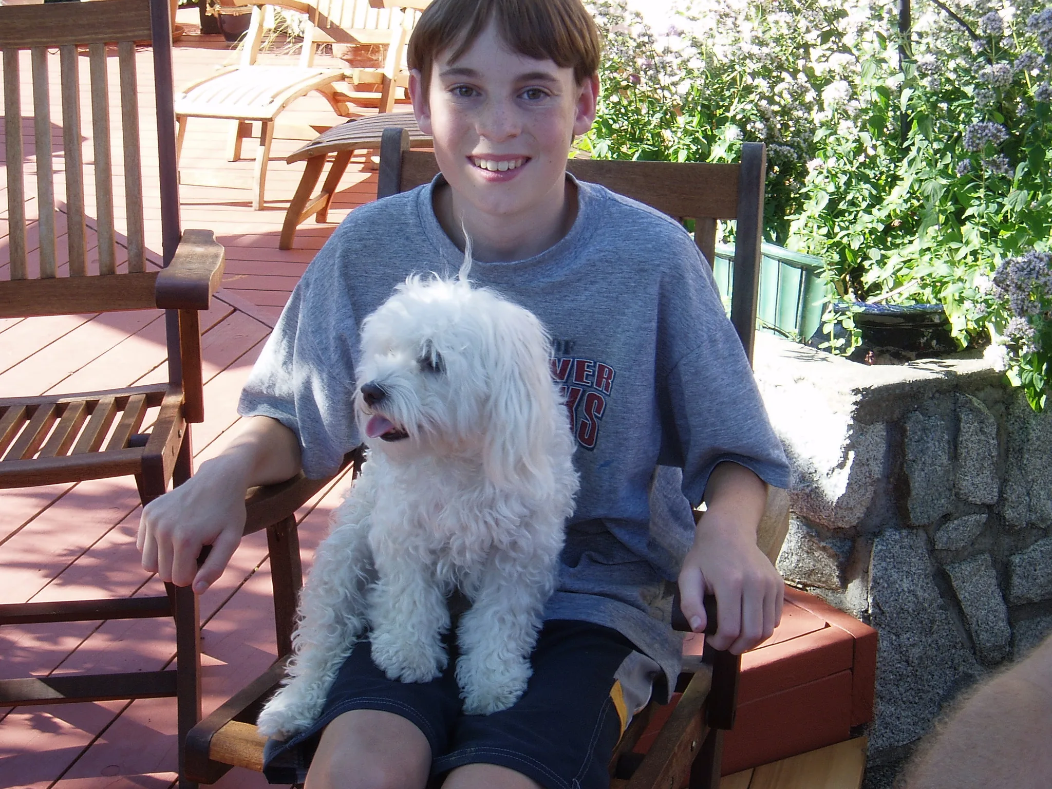 Young Owen sitting outside with a small white dog
